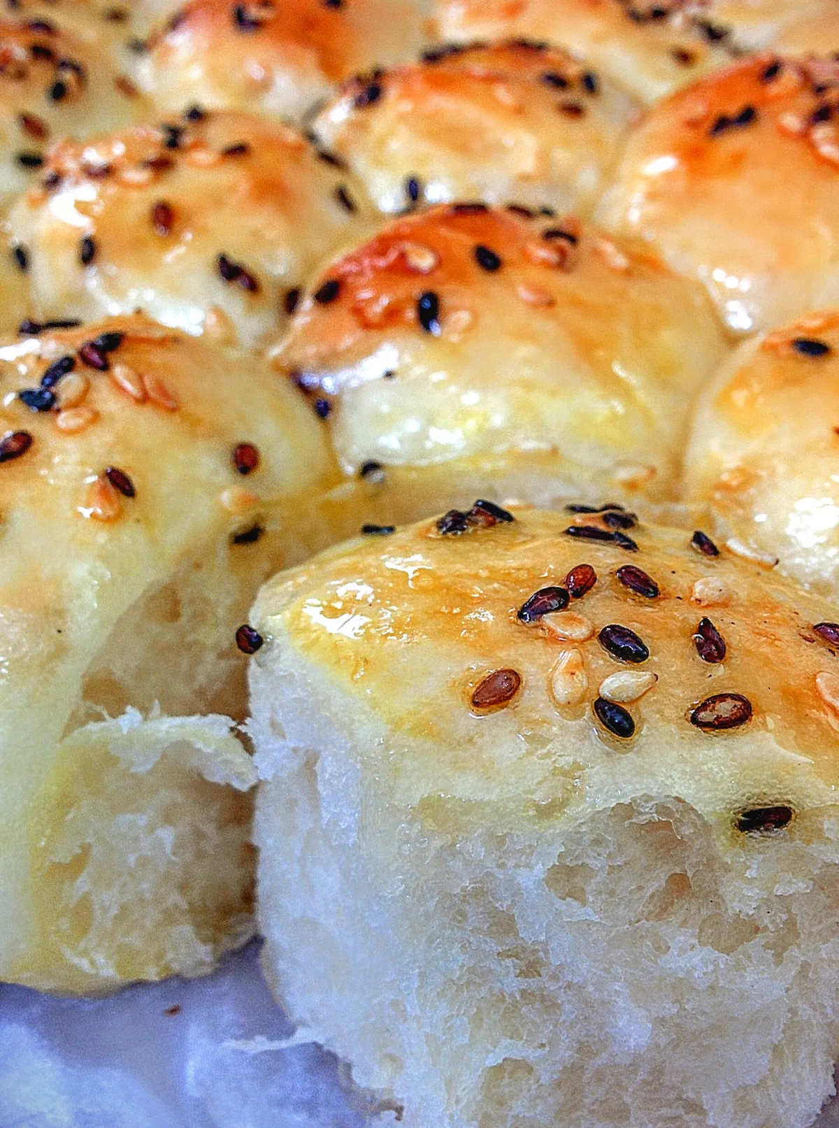 Honeycomb bun with cream cheese filling ,topped with roasted sesame seeds and ginger honey glaze